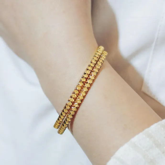 A close up of a person wearing a gold bracelet